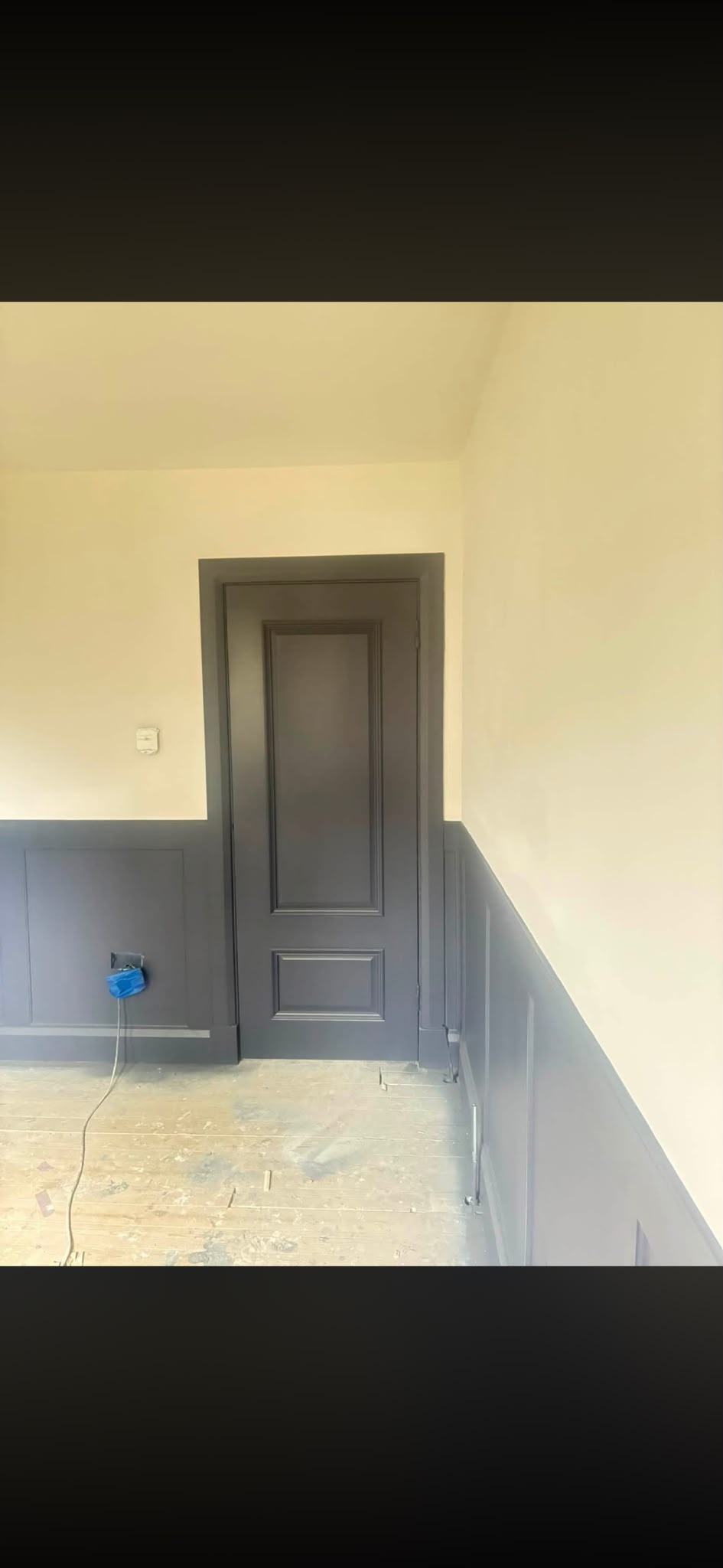 Grey panelled walls and a matching painted door