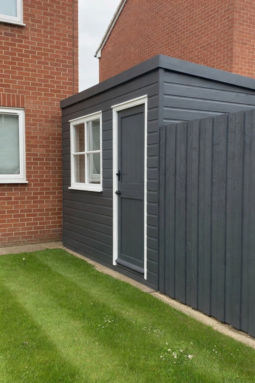 Freshly painted charcoal garden shed and matching timber fence